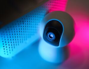 A modern outdoor security camera with a spotlight mounted on a contemporary home wall.