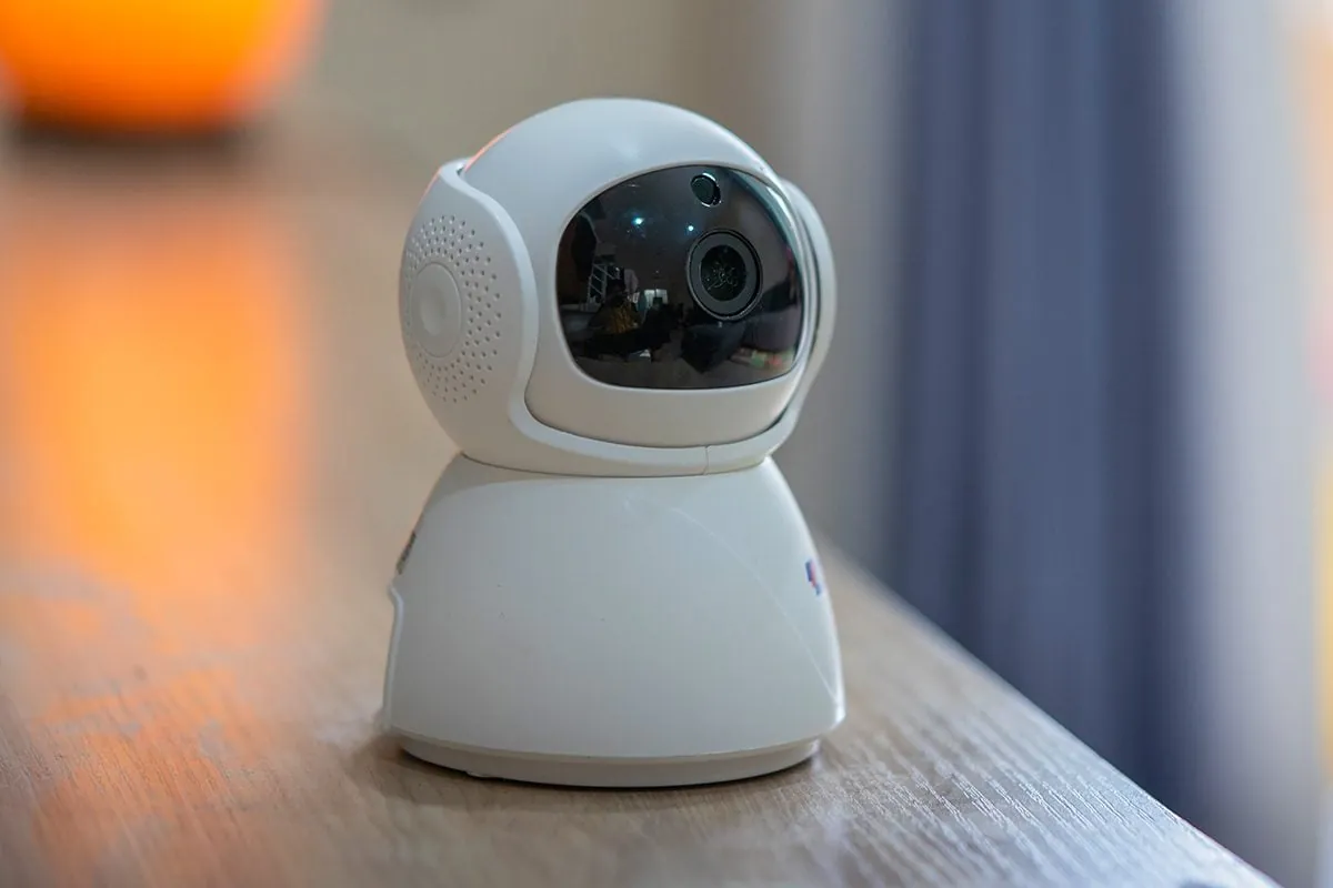 Security camera and phone showing live view near a Wi-Fi router