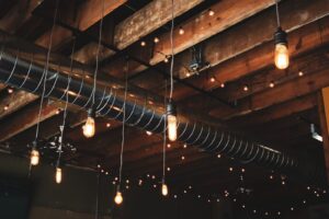 Warm LED lights illuminate rustic ceiling beams in a modern, stylish living room interior.